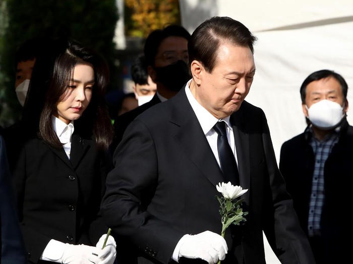 SEOUL, SOUTH KOREA - OCTOBER 31:  South Korean President Yoon Suk-yeol and his wife Kim Kun-hee hold flowers at a memorial altar for the victims of the Halloween celebration stampede, in front of City Hall on October 31, 2022 in Seoul, South Korea. One hundred and fifty-one people have been reported killed and at least 150 others were injured in a deadly stampede in Seoul's Itaewon district, after huge crowds of people gathered for Halloween parties, according to fire authorities. (Photo by Chung Sung-Jun/Getty Images)