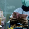 A teller counts Indonesian rupiah bank notes at a money changer in Jakarta, Indonesia, October 14, 2022. REUTERS/Willy Kurniawan
