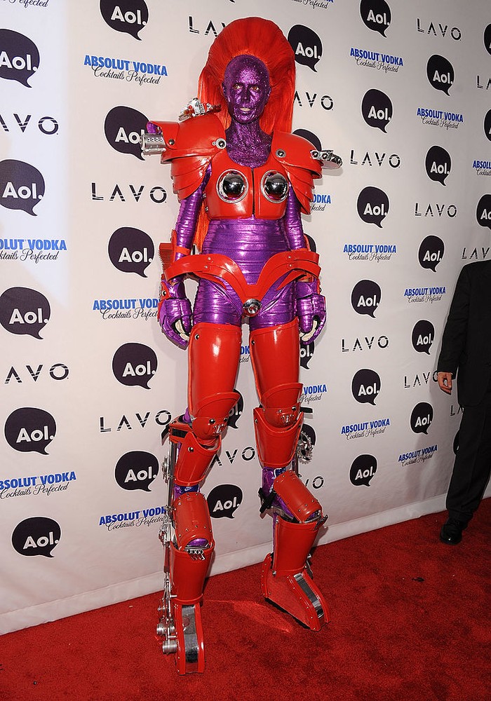 Tahun 2010, Heidi Klum jadi robot tinggi. Agar bisa selaras dengan warna ungu kostum, ia pun menghiasi wajahnya dengan glitter senada.Foto: Getty Images/Bryan Bedder