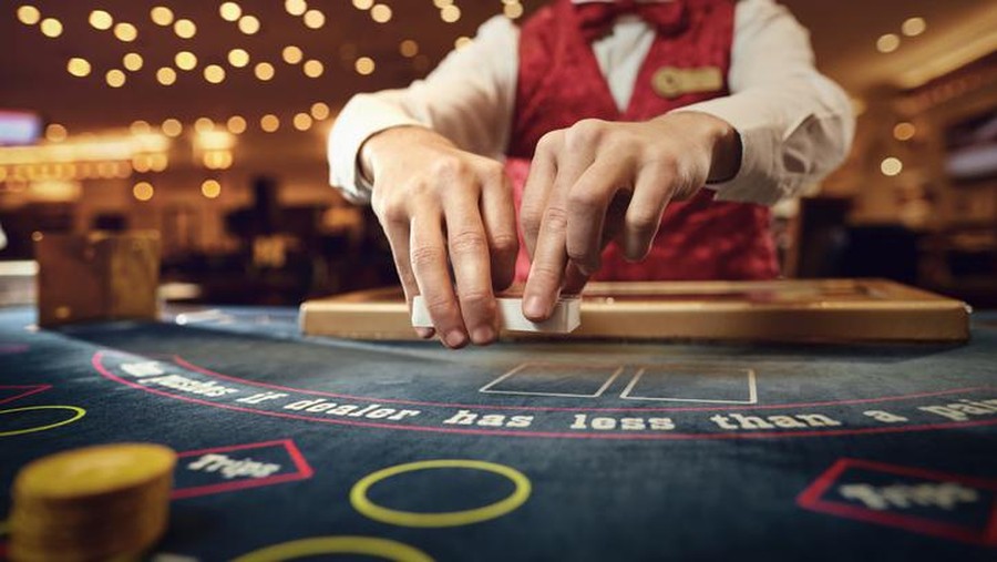 Berjudi The croupier holds poker cards in his hands at a table in a casino.