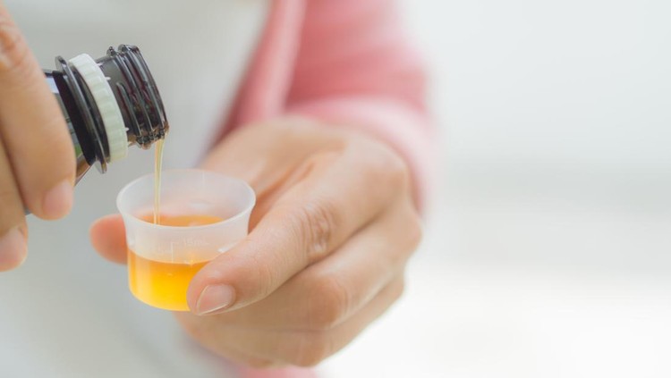 Ilustrasi Penyebab Lain Gagal Ginjal Akut healthcare, people and medicine concept - woman pouring medication or antipyretic syrup from bottle to cup