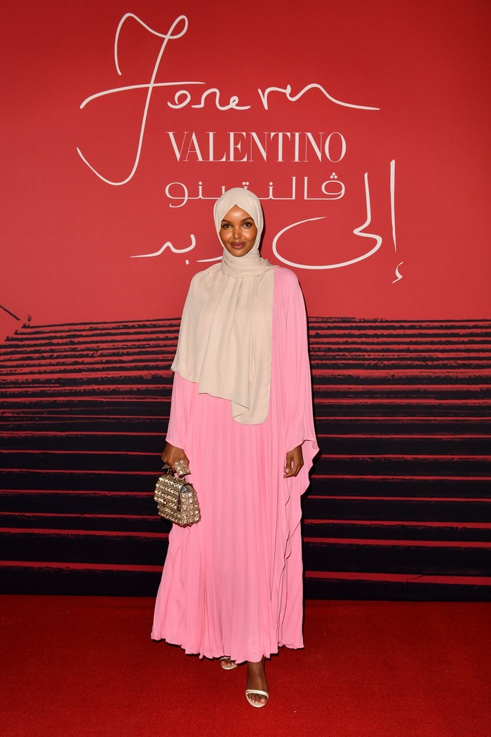 Model Halima Aden memilih rona pink yang lebih pucat dan dipadukan dengan hijab dan aksesori berwarna netral. So chic! Foto: Valentino / Getty Images
