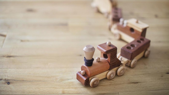 retro wooden toy train set on hardwood floor