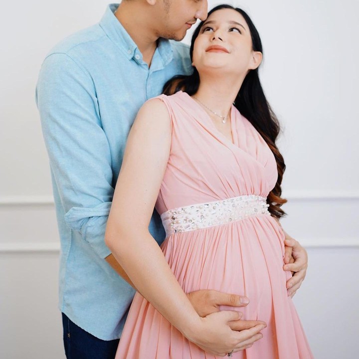 <p>Dalaman <em>maternity shoot</em>-nya Yasmine tampil memesona dengan balutan <em>dress pink</em> tanpa lengan bersama sang suami yang tampak mengenakan kemeja berwarna biru. (Foto: Instagram @yxsmine.ow/@bangpeng__)</p>