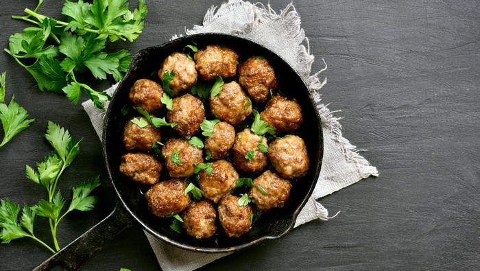 Meatballs in frying pan on black stone background with copy space. Top view, flat lay