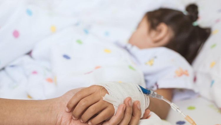 Ilustrasi Awal Mula Ditemukan Gagal Ginjal Akut pada Anak Mother hand holding sick daughter hand who have IV solution bandaged with love and care while she is sleeping on bed in the hospital