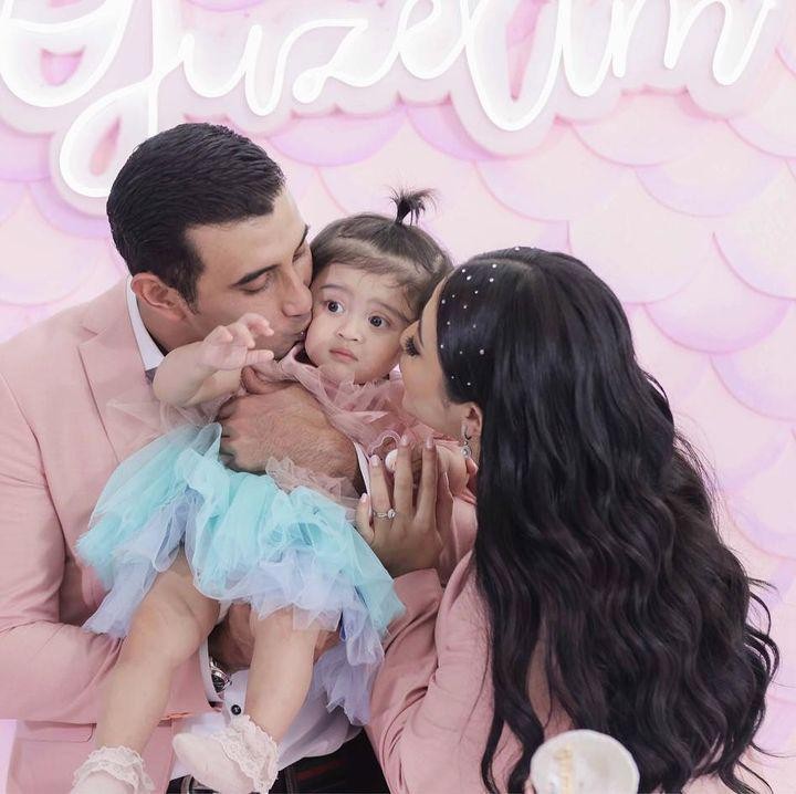 <p>Guzel bersama kedua orang tuanya kompak mengenakan pakaian serba merah muda, Bunda. Ekspresinya pun terlihat sangat menggemaskan. (Foto: Instagram: @guzelimalisyakieb)</p>