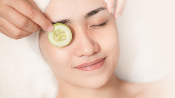 beautiful women facial skin care eyes wrinkle cucumber treatment in spa salon relax happy smile.