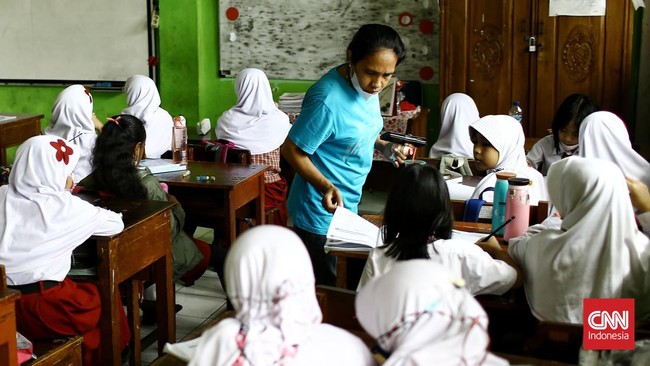 Nuraeni setiap hari membawa adiknya ke sekolah sejak ibunya meninggal dunia enam bulan lalu. Dia menggendong adiknya sambil belajar di ruang kelas.