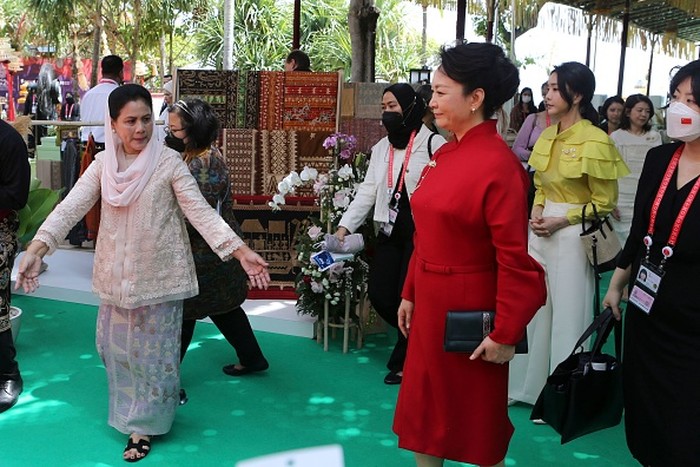 First Lady China, Peng Liyuan bergaya elegan dalam gaun merah aksen belt dan clutch hitam. Foto: POOL/AFP via Getty Images/FIRDIA LISNAWATI