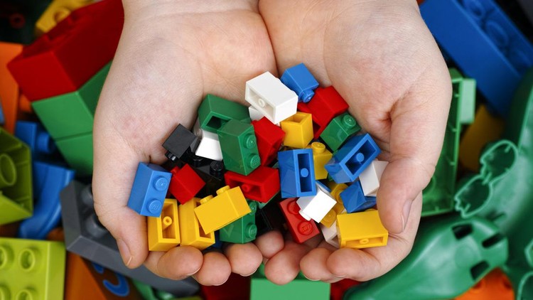 Ilustrasi Kegiatan Bermain Anak Tambov, Russian Federation - February 20, 2015 Lego Bricks in child's hands with Lego Duplo blocks and toys background. Studio shot.