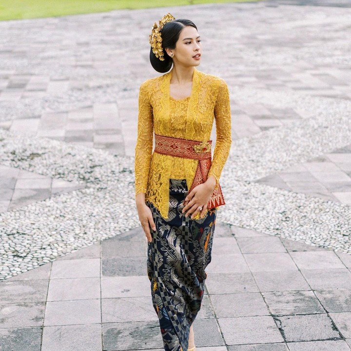 <p>Kebaya khas Bali itu membalut tubuhnya sehingga terlihat ramping dan elegan. Maudy memilih kebaya warna mustard yang dipadu dengan kain bernuansa gelap. (Foto: Instagram @maudyayunda by @gusmankphotography)</p>
