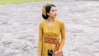 <p>Kebaya khas Bali itu membalut tubuhnya sehingga terlihat ramping dan elegan. Maudy memilih kebaya warna mustard yang dipadu dengan kain bernuansa gelap. (Foto: Instagram @maudyayunda by @gusmankphotography)</p>