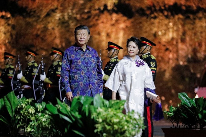 Di acara makan malam, Peng Liyuan memakai gaun cheongsam berpotongan longgar dengan selendang tenun selaras dengan kemeja sang suami Xi Jinping. Foto: Willy Kurniawan/AFP/Pool/Getty Images
