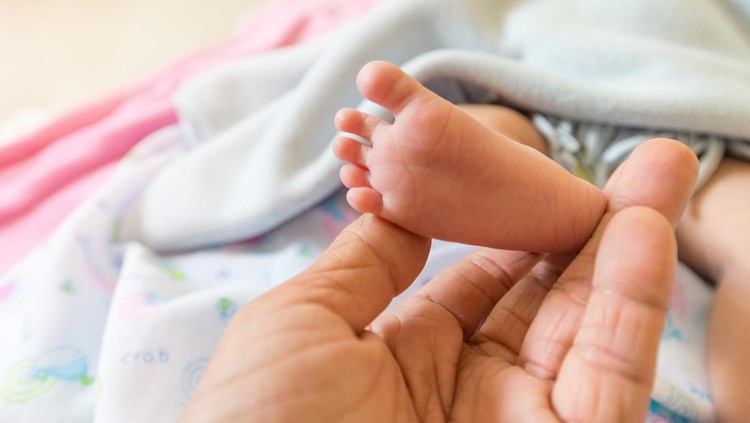 Baby's foot With the hands of older adults