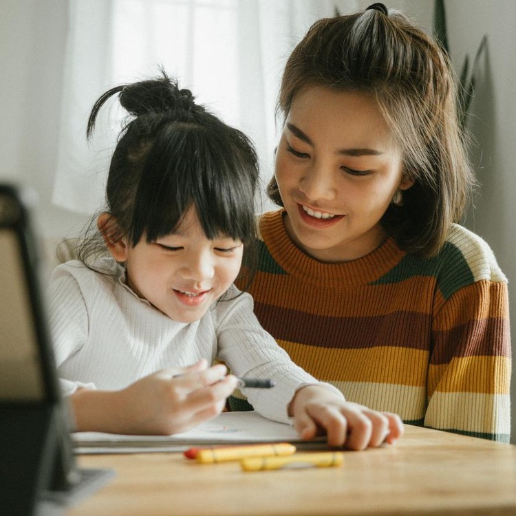 Ilustrasi Rahasia Orang Tua Besarkan Anak Sukses Asian mother and daughter doing homework at home. The school has been closed during coronavirus outbreak and the classes have moved to e-learning platform.