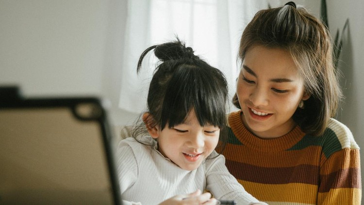 Ilustrasi Rahasia Orang Tua Besarkan Anak Sukses Asian mother and daughter doing homework at home. The school has been closed during coronavirus outbreak and the classes have moved to e-learning platform.