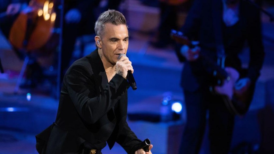 HAMBURG, GERMANY - NOVEMBER 15: Robbie Williams performs live at the Telekom Street Gigs with a large orchestra, new songs and the Beethoven AI at the Hamburg Elbphilharmonie on November 15, 2022 in Hamburg, Germany. (Photo by Andreas Rentz/Getty Images)