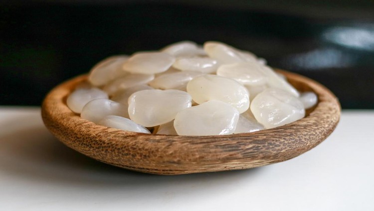 1146700339 Sugar palm fruit on wooden plate on black background.