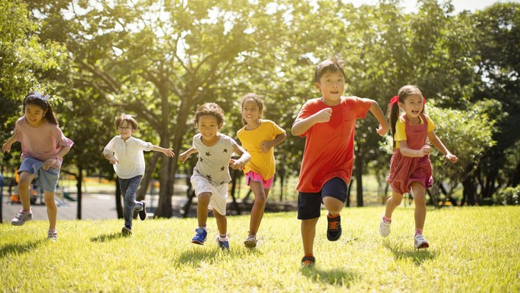 Multi-ethnic group of school children laughing and running