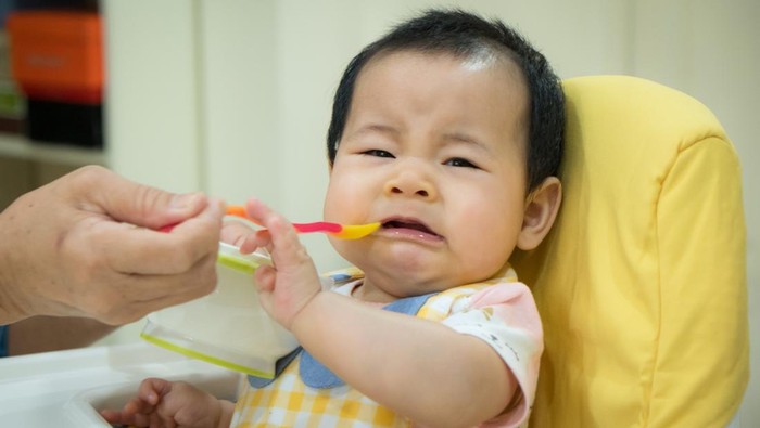 Asian baby girl refusing to eat food.tradition weaning