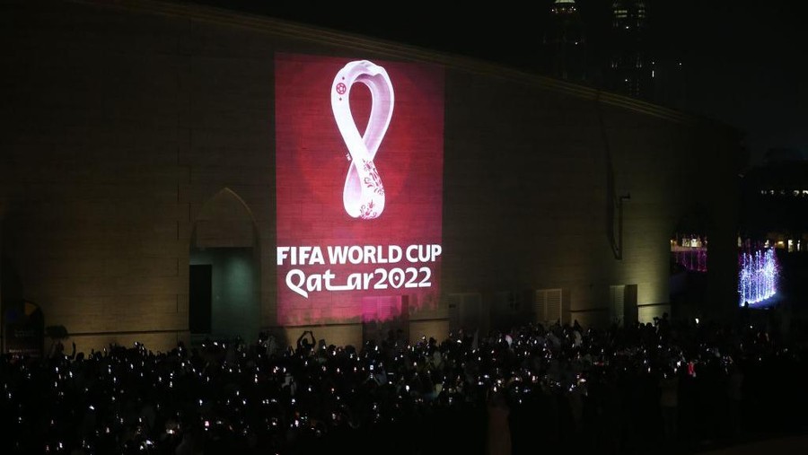 Logo Piala Dunia 2022 DOHA, QATAR - SEPTEMBER 03: Hundreds of people take a photo as the official logo of the 'FIFA World Cup Qatar 2022' is reflected on a wall of the Amphitheatre in Doha, Qatar on September 03, 2019.

 (Photo by Mohammed Dabbous/Anadolu Agency via Getty Images)