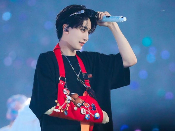 Tampil simpel dengan t-shirt hitam, Jeonghan tidak membiarkan gipsnya tenggelam. Ia mengenakan gips berwarna merah terang dengan kancing dan gantungan kunci yang membuat tampilannya ramai dan gemas./ Foto: koreaboo.com