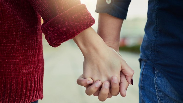 Cropped shot of a couple holding hands outdoors