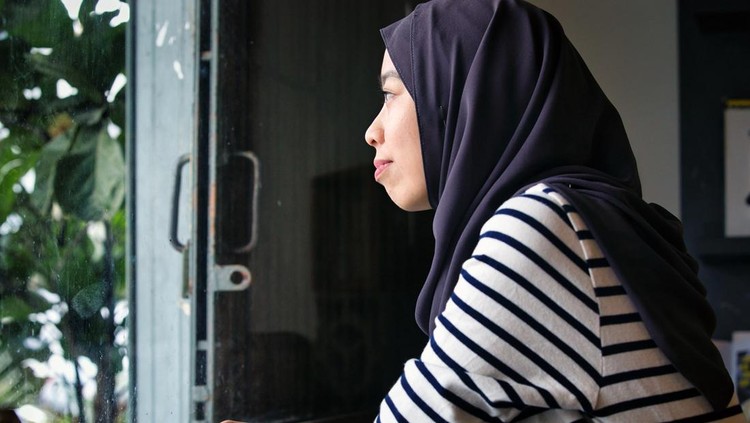 1411866338 Woman seated at a cafe and looking outside the window