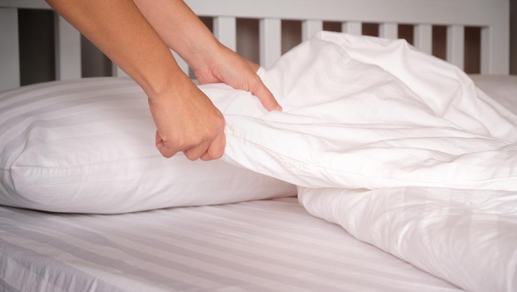 The hands of housewives who are changing sheets in hotels.