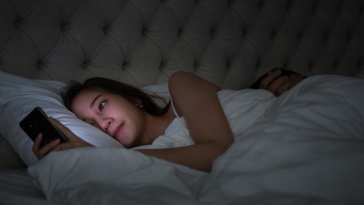 Young Couple On Bed With Smart Phone