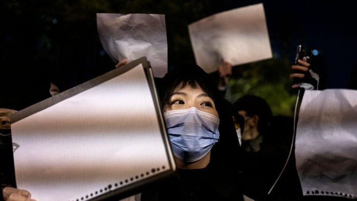 BEIJING, CHINA -NOVEMBER 27: Protesters hold up a white piece of paper against censorship as they march during a protest against Chinas strict zero COVID measures on November 27, 2022 in Beijing, China. Protesters took to the streets in multiple Chinese cities after a deadly apartment fire in Xinjiang province sparked a national outcry as many blamed COVID restrictions for the deaths. (Photo by Kevin Frayer/Getty Images)