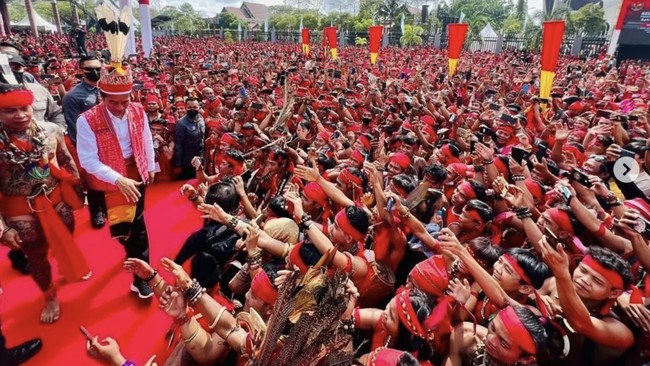 Ribuan warga Suku Dayak dengan pakaian serba merah menyambut Presiden Jokowi saat tiba di Pontianak, Kalbar.