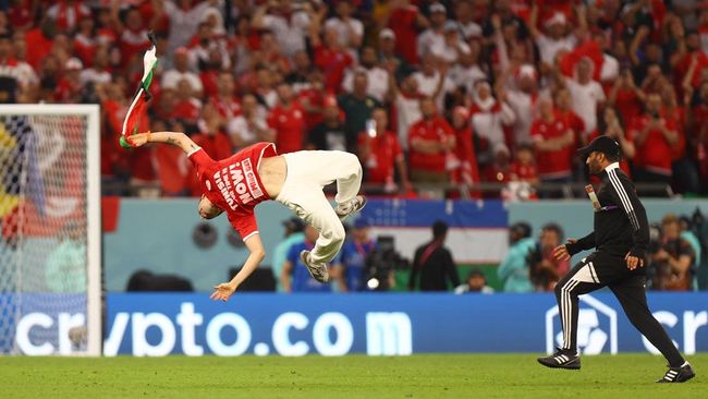 Seorang pria menyusup sambil akrobat dan membawa bendera Palestina ke pertandingan Tunisia vs Prancis di Piala Dunia 2022.
