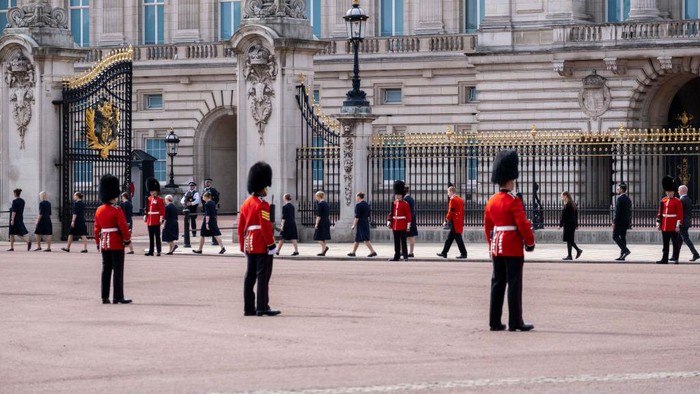 Grenadier Guards stand on duty deliniating the procession route outside Buckingham Palace as palace staff take their places to pay their respects at the State Funeral of Queen Elizabeth II on 19th September 2022 in London, United Kingdom. 11 days after it was announced that the Queen had passed away, hundreds of thousands of people gathered in central London to witness the funeral procession. (photo by Mike Kemp/In Pictures via Getty Images)