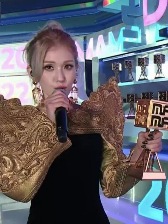 Outfit So Mi yang satu ini juga memiliki gaya yang unik, Beauties. Perpaduan warna emas dan hitam dalam outfit yang ia kenakan juga membuatnya tampil makin standout./ Foto: kpopstarz.com