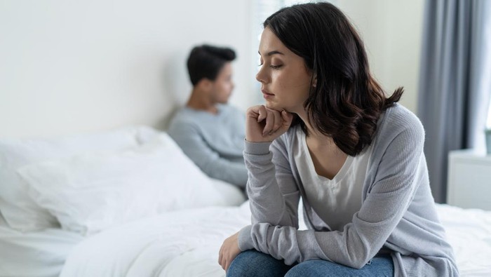 Asian young girl feel angry boyfriend having conflict domestic problem. New marriage man and woman feel heartbroken for quarrel conflict while sit on bed in bedroom. Family problem-separation concept.