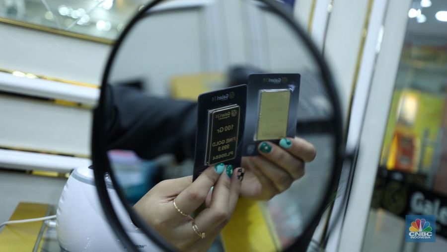 Karyawan menunjukkan emas Antam di gerai Galeri 24 Pegadaian di Jakarta, Senin (5/12/2022). Harga emas batangan di PT Pegadaian bergerak stagnan pada perdagangan hari ini, Senin (5/12/2022). Pegadaian sendiri menjual berbagai jenis emas, yaitu emas Antam, Antam Retro, Antam Batik, dan UBS. Ukurannya pun dijual beragam, mulai dari 0,5 gram hingga 1.000 gram. Pada perdagangan hari ini, harga emas Antam ukuran 1 gram dibanderol Rp 1.033.000. (CNBC Indonesia/Tri Susilo)