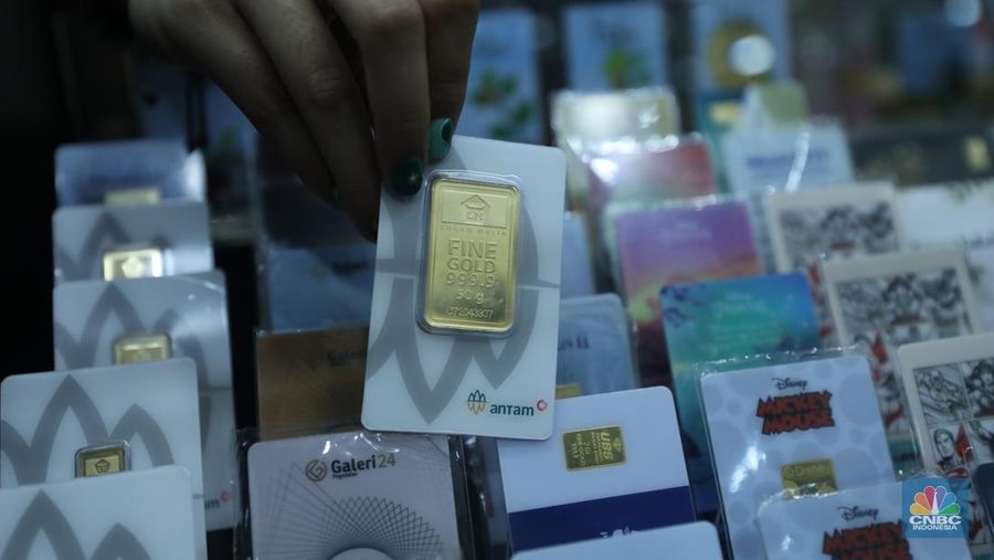 Karyawan menunjukkan emas Antam di gerai Galeri 24 Pegadaian di Jakarta, Senin (5/12/2022). Harga emas batangan di PT Pegadaian bergerak stagnan pada perdagangan hari ini, Senin (5/12/2022). Pegadaian sendiri menjual berbagai jenis emas, yaitu emas Antam, Antam Retro, Antam Batik, dan UBS. Ukurannya pun dijual beragam, mulai dari 0,5 gram hingga 1.000 gram. Pada perdagangan hari ini, harga emas Antam ukuran 1 gram dibanderol Rp 1.033.000. (CNBC Indonesia/Tri Susilo)