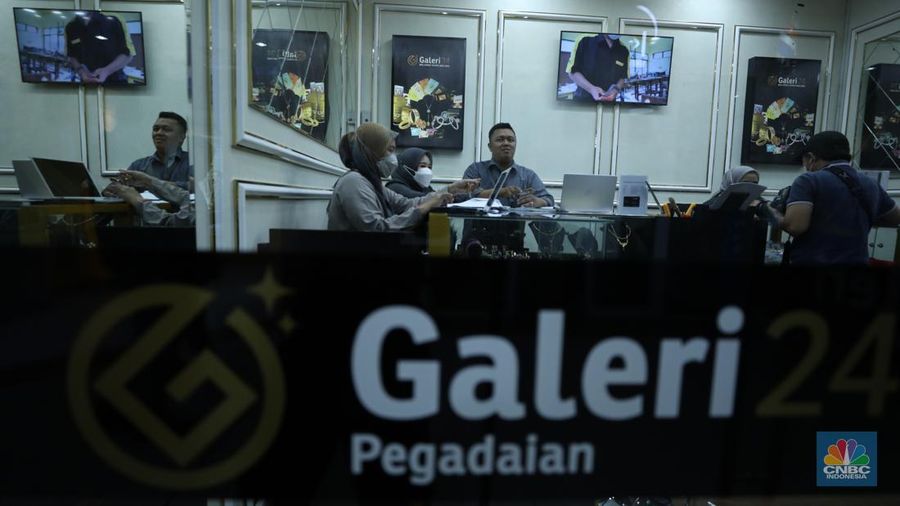 Karyawan menunjukkan emas Antam di gerai Galeri 24 Pegadaian di Jakarta, Senin (5/12/2022). Harga emas batangan di PT Pegadaian bergerak stagnan pada perdagangan hari ini, Senin (5/12/2022). Pegadaian sendiri menjual berbagai jenis emas, yaitu emas Antam, Antam Retro, Antam Batik, dan UBS. Ukurannya pun dijual beragam, mulai dari 0,5 gram hingga 1.000 gram. Pada perdagangan hari ini, harga emas Antam ukuran 1 gram dibanderol Rp 1.033.000. (CNBC Indonesia/Tri Susilo)