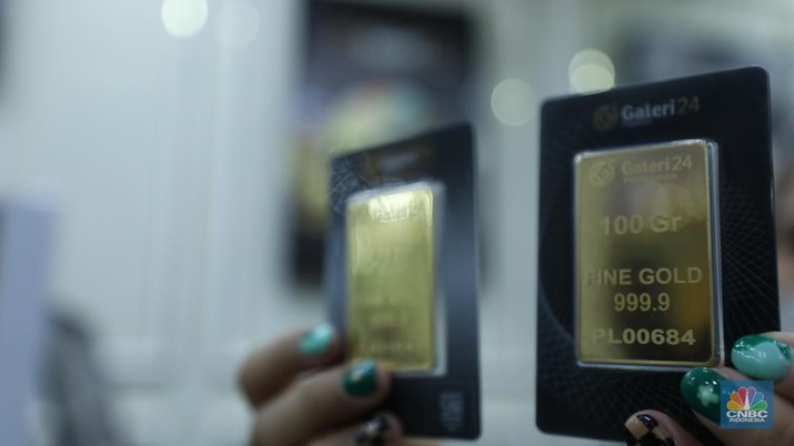 Karyawan menunjukkan emas Antam di gerai Galeri 24 Pegadaian di Jakarta, Senin (5/12/2022). Harga emas batangan di PT Pegadaian bergerak stagnan pada perdagangan hari ini, Senin (5/12/2022). Pegadaian sendiri menjual berbagai jenis emas, yaitu emas Antam, Antam Retro, Antam Batik, dan UBS. Ukurannya pun dijual beragam, mulai dari 0,5 gram hingga 1.000 gram. Pada perdagangan hari ini, harga emas Antam ukuran 1 gram dibanderol Rp 1.033.000. (CNBC Indonesia/Tri Susilo)