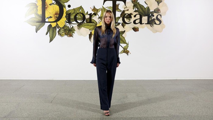 Lila Moss, model dan putri dari Kate Moss terlihat elegan memakai kombinasi blus transparan dan celana panjang. Foto: Getty Images For Christian Dior/Pascal Le Segretain