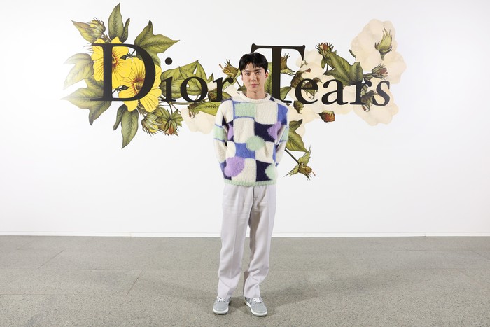 Sehun tampil simpel dan kasual dalam sweater bermotif grafis bernuansa warna pastel. Foto: Getty Images For Christian Dior/Pascal Le Segretain
