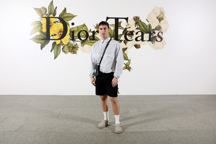 Benito Skinner atau yang populer dengan nama Benny Drama bergaya preppy dalam balutan kemeja, celana pendek, dan sepatu Birkenstock.Foto: Getty Images For Christian Dior/Pascal Le Segretain
