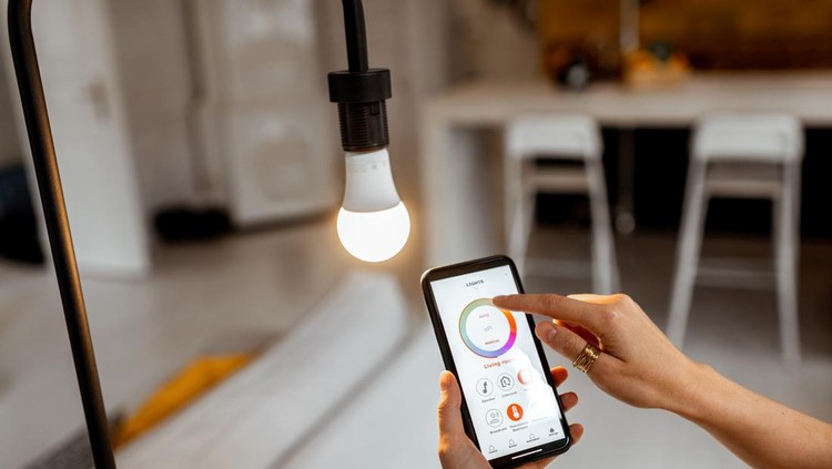 1215074546 Controlling light bulb temperature and intensity with a smartphone application. Concept of a smart home and managing light with mobile devices
