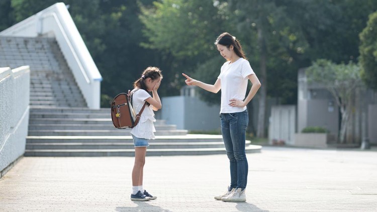 A woman scolding an elementary school student