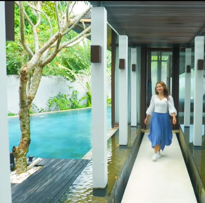 <p>Villa Rossa di Bali dikelilingi air di setiap sudutnya. Dari ruang tengah menuju kamar utama, terdapat kolam air di villa milik diva Indonesia ini. Terlihat sejuk banget, ya Bun. (Foto: YouTube/Rossa Official)</p>