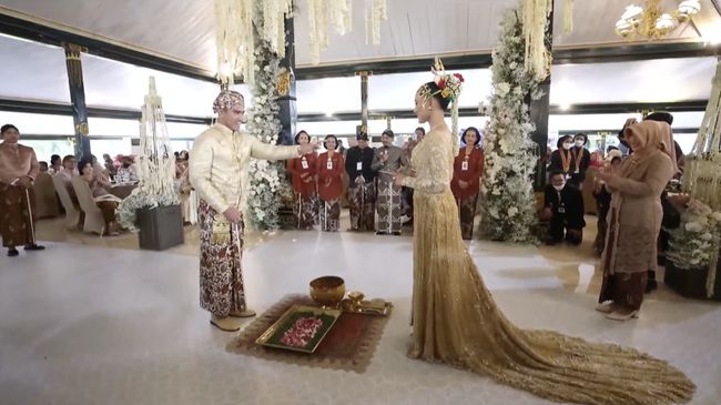 Pasangan suami istri baru, Kaesang Pangarep dan Erina Gudono, terlihat tertawa satu dengan yang lain saat prosesi lempar sirih, Sabtu (10/12). 
