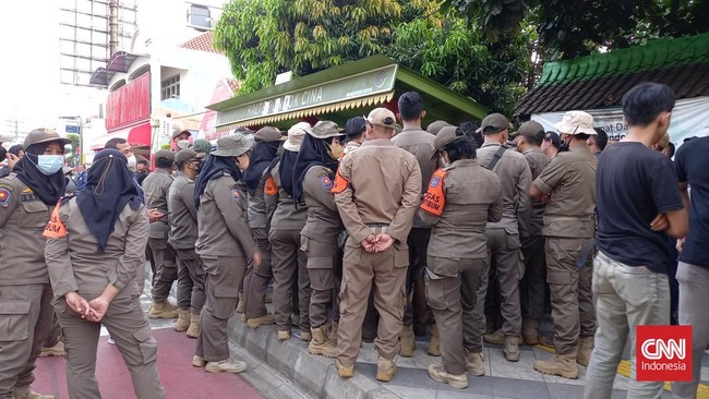 Satpol PP yang akan mengambil aset serta menghancurkan gedung sekolah SDN Pondok Cina 1 tidak bisa masuk. Orang tua murid telah berjaga di gerbang.