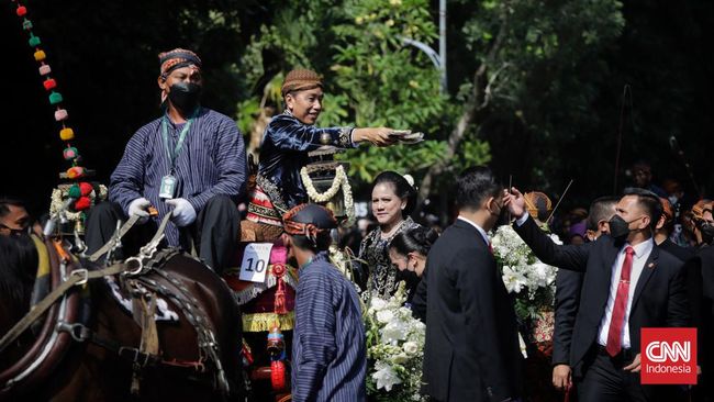 FOTO: Jokowi Bagi-bagi Suvenir ke Warga Saat Kirab Kaesang-Erina